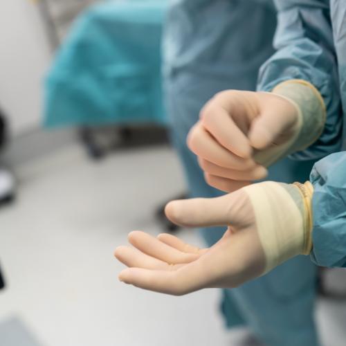 Médecin qui met ses gants dans un bloc opératoire