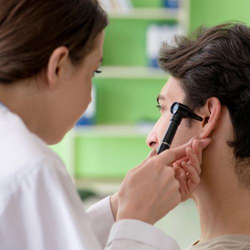 Médecin femme qui examine l'oreille d'un homme